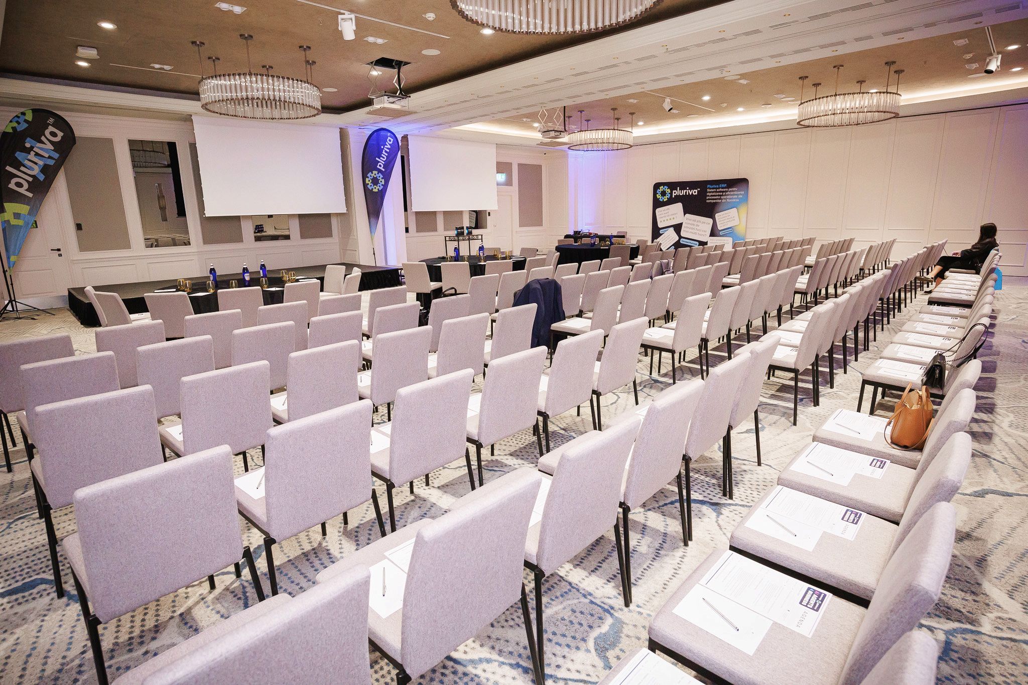 Sala de conferință pregătită înainte de eveniment, cu agende pe scaune